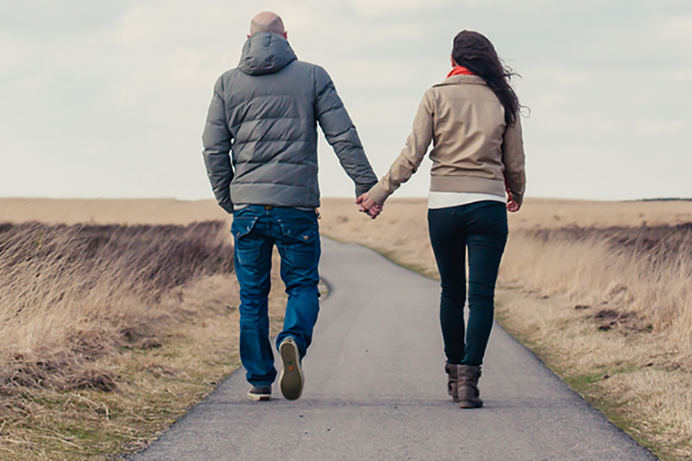 Jeune couple se tenant la main à la campagne.